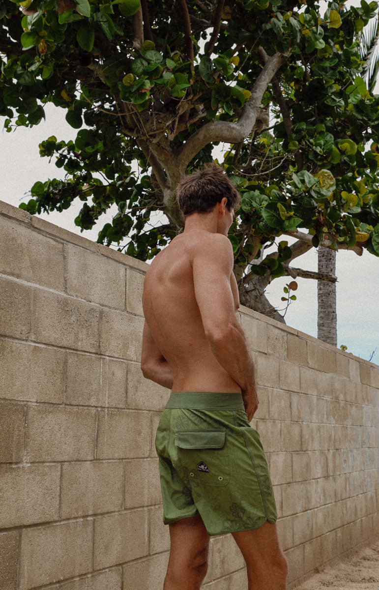 Austin boardshorts in Isthmus green hibiscus floral sustainable recycled swim trunks designed in hawaii oahu kailua 4 way stretch recycled repreve comfy shorts made from plastic water bottles 6 inch inseam with piping and back velcro pocket with patches and custom sewn on handmade logo patches with trees pinterest artsy photography background