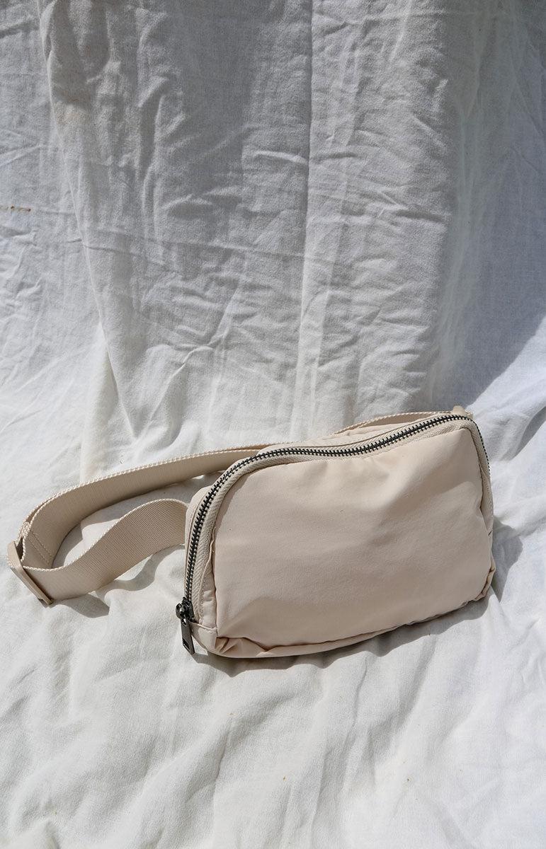 A cross body bag made from recycled materials, resembling a 1L size and inspired by Lululemon. The bag features vibrant colors reminiscent of bikinis, making it a stylish and sustainable accessory from hawaii kailua oahu sustainable swimwear accessories tai swim co holo holo bag in haupia