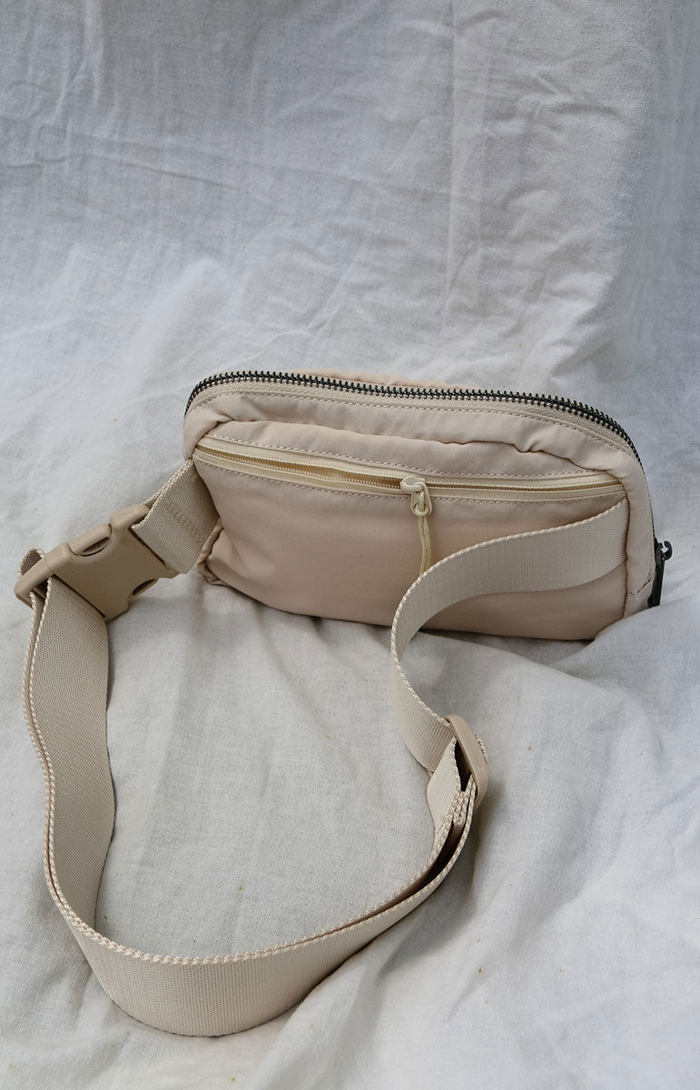 A cross body bag made from recycled materials, resembling a 1L size and inspired by Lululemon. The bag features vibrant colors reminiscent of bikinis, making it a stylish and sustainable accessory from hawaii kailua oahu sustainable swimwear accessories tai swim co holo holo bag in haupia