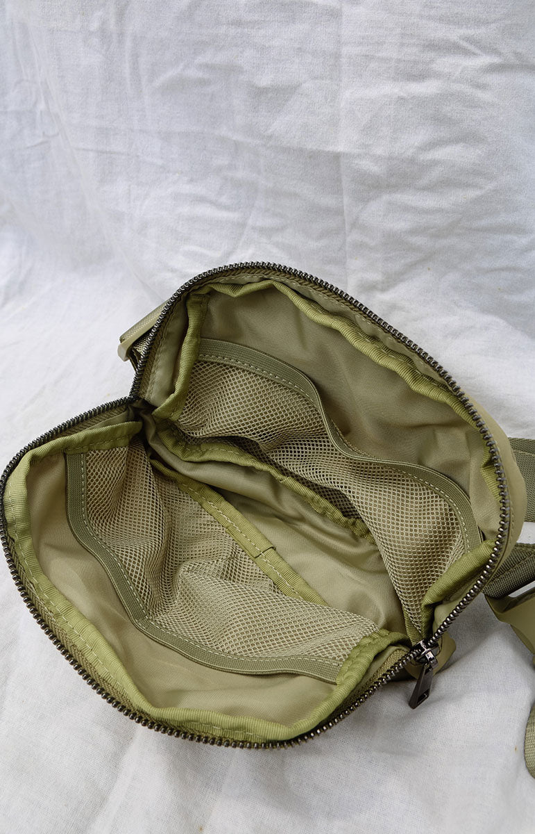 A cross body bag made from recycled materials, resembling a 1L size and inspired by Lululemon. The bag features vibrant colors reminiscent of bikinis, making it a stylish and sustainable accessory from hawaii kailua oahu sustainable swimwear accessories tai swim co holo holo bag in sage