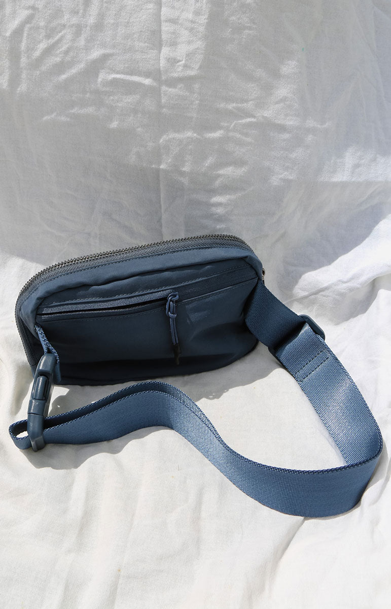 A cross body bag made from recycled materials, resembling a 1L size and inspired by Lululemon. The bag features vibrant colors reminiscent of bikinis, making it a stylish and sustainable accessory from hawaii kailua oahu sustainable swimwear accessories tai swim co holo holo bag in rift
