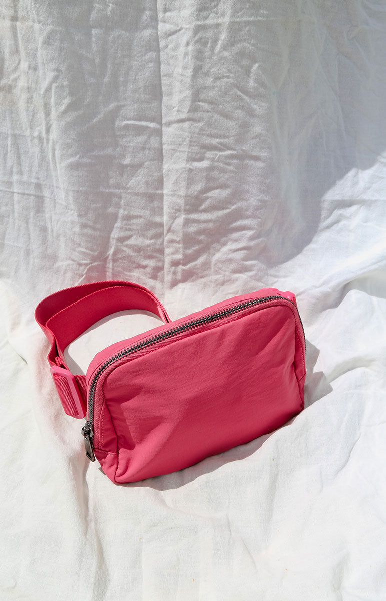 A cross body bag made from recycled materials, resembling a 1L size and inspired by Lululemon. The bag features vibrant colors reminiscent of bikinis, making it a stylish and sustainable accessory from hawaii kailua oahu sustainable swimwear accessories tai swim co holo holo bag in lehua