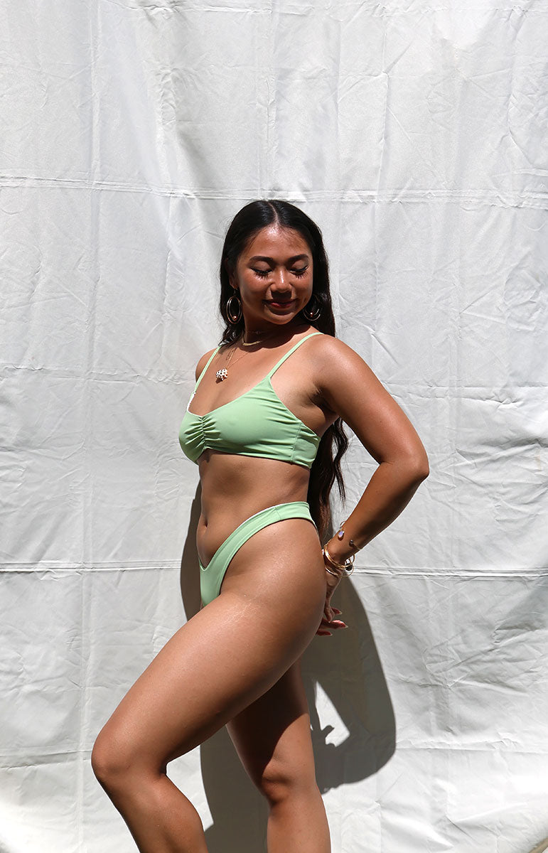 tai swim co matcha emma top in green ribbed textured comfy fabric from hawaii sunlight scoop neck scrunchy bra top bikini with regular classic bikini thong bottom reversible seamless stitching in hawaii kailua oahu sunny photography from kailua hawaii oahu tanned girl from honolulu
