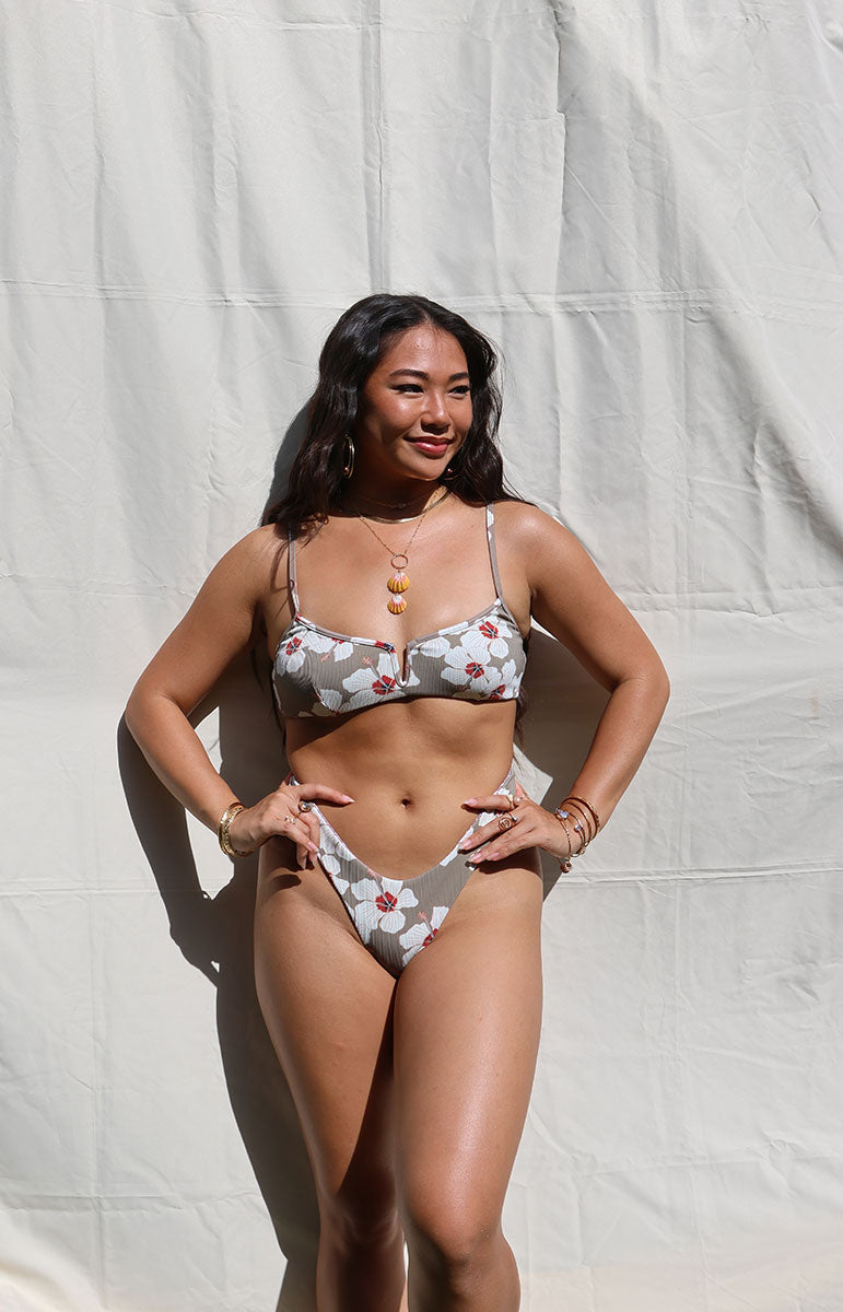 tai swim co haley top in kailua white floral hibiscus print bikini top with v cut scoop neck shape on sunny oahu island hawaii day with sunrise shell necklace in bright lighting with matching mariah bottom
