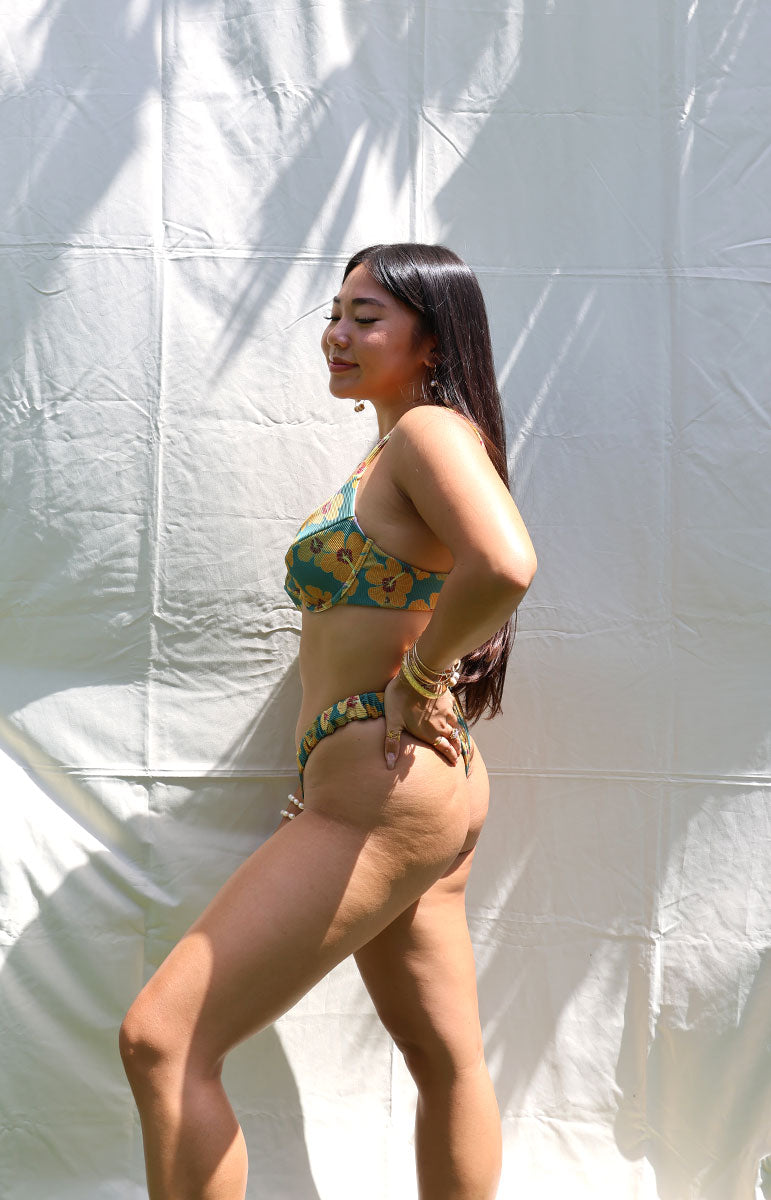 tai swim co jade underwire bra top in milo yellow floral hawai ihibiscus from tai swim co summer 2024 collection its a green emerald background bikini solid with yellow and orange maroon flowers from hawaii oahu kailua scoop style flattering bra top supportive good for big chested girls from kailua drawn by tai