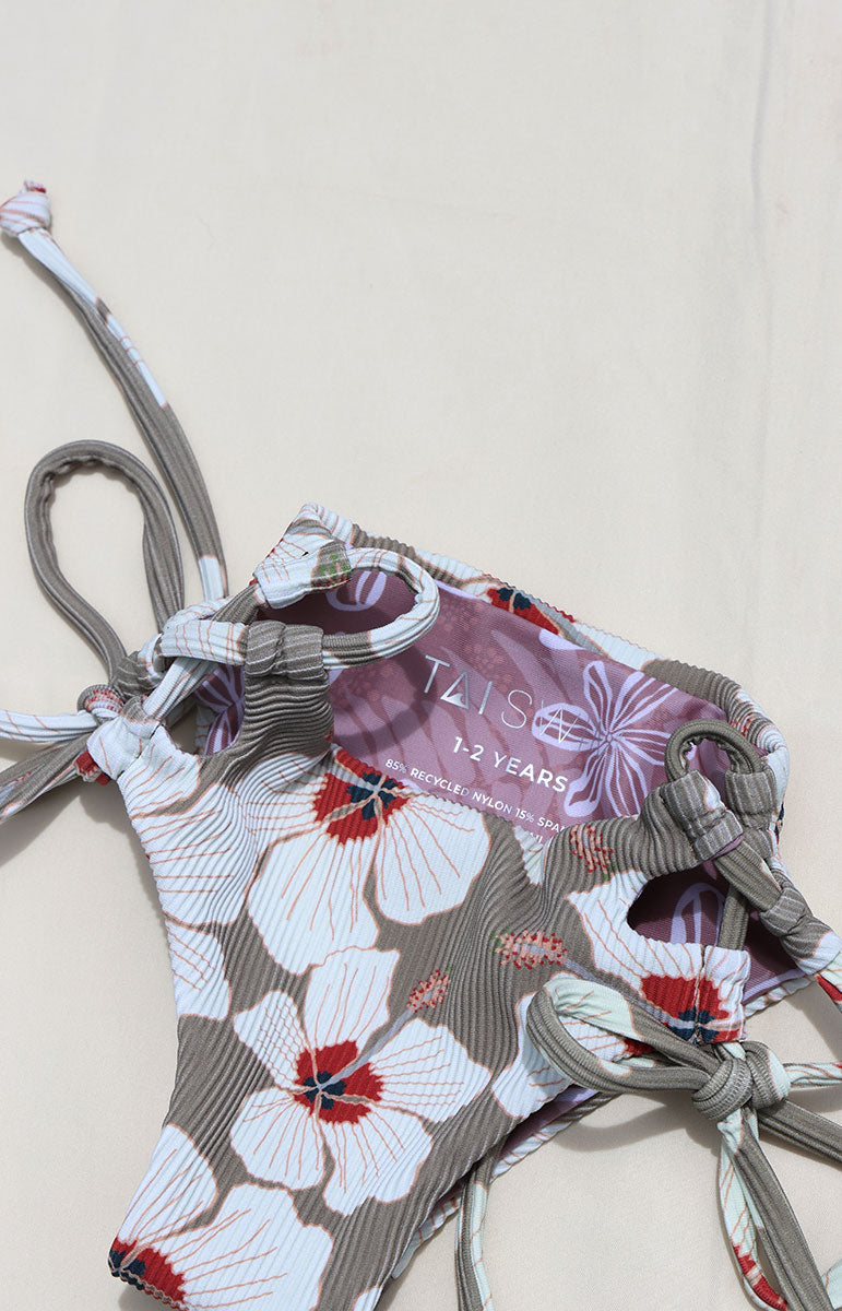 Tai Swim Co Keiki swim set in Kailua print featuring a full-coverage tie-side bikini bottom and matching tie-back top, displayed flat on a neutral background made with sustainable eco friendly materials reversible cute skimpy kids bikini white hand drawn hibiscus flowers