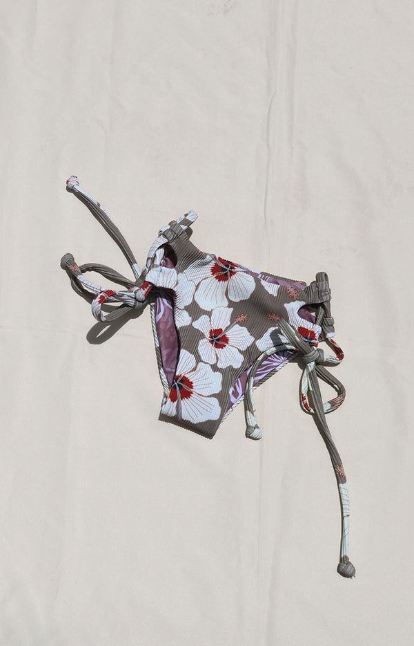 Tai Swim Co Keiki swim set in Kailua print featuring a full-coverage tie-side bikini bottom and matching tie-back top, displayed flat on a neutral background made with sustainable eco friendly materials reversible cute skimpy kids bikini white hand drawn hibiscus flowers