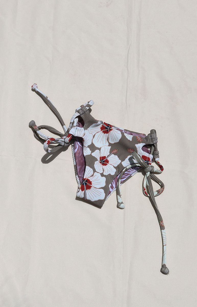 Tai Swim Co Keiki swim set in Kailua print featuring a full-coverage tie-side bikini bottom and matching tie-back top, displayed flat on a neutral background made with sustainable eco friendly materials reversible cute skimpy kids bikini white hand drawn hibiscus flowers