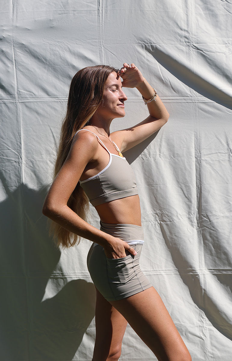 tai swim co kylie top and shorts in chai sustainable eco friendly workout gear from oahu kailua hawaii ribbed light tan materials with triangle wave white logo tai swim co branding kailua oahu hawaii piping two tone ribbed bikini material workout sets ribbed piping two tone sustainable materials bikini sets