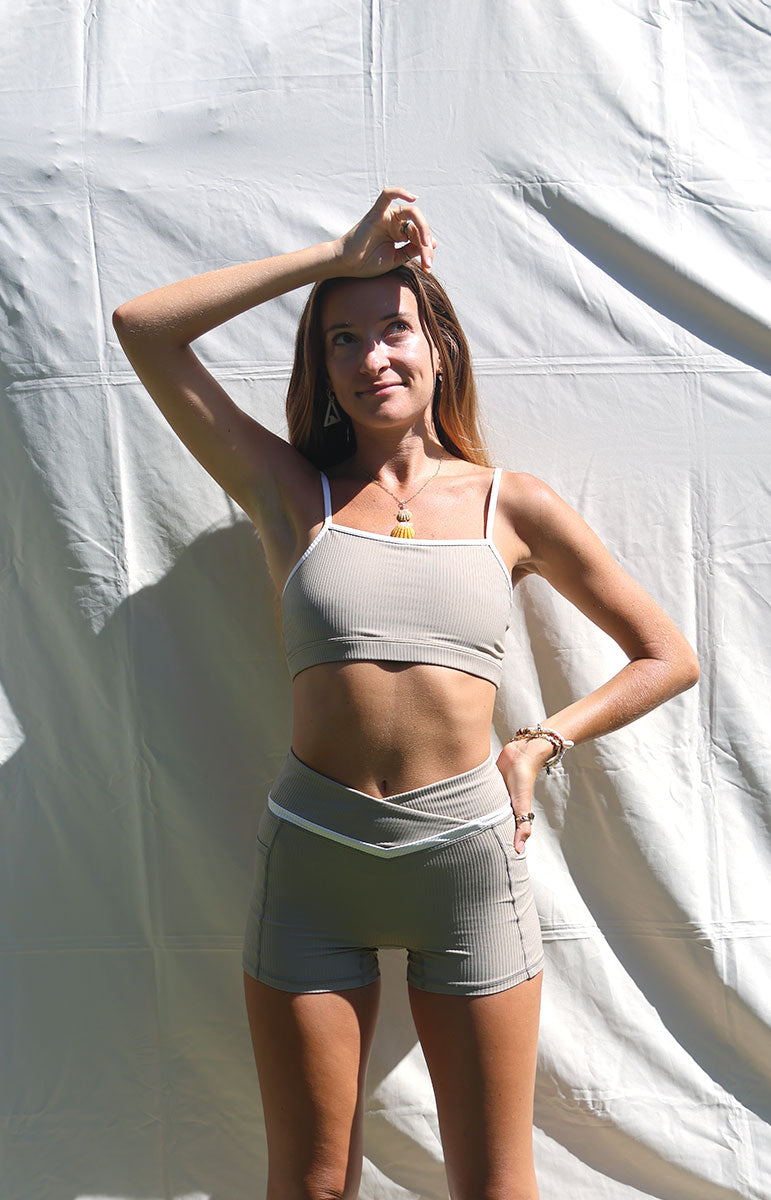 tai swim co kylie shorts in chai sustainable eco friendly workout gear from oahu kailua hawaii ribbed light tan materials with triangle wave white logo tai swim co branding kailua oahu hawaii tan white light color workout sets