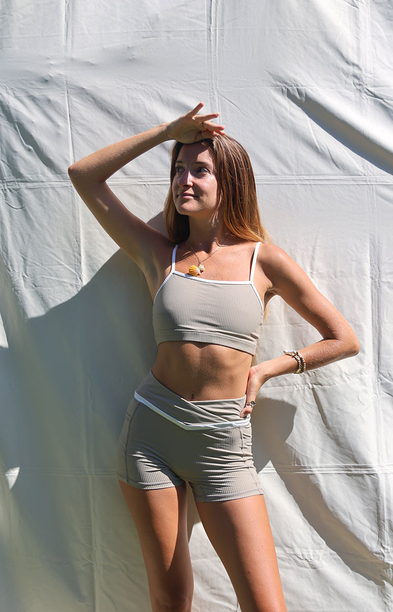 tai swim co kylie top and shorts in chai sustainable eco friendly workout gear from oahu kailua hawaii ribbed light tan materials with triangle wave white logo tai swim co branding kailua oahu hawaii piping two tone ribbed bikini material workout sets