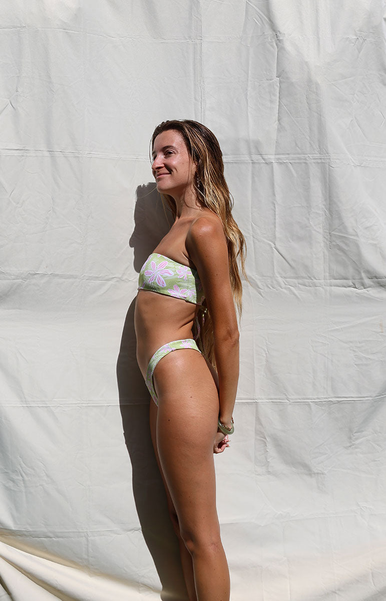 Woman wearing a floral bikini against a white background tai swim co maddie top in hawi green and pink floral cheeky hawaii bikinis from kailua