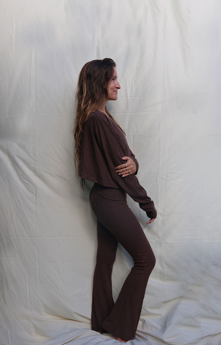 Person wearing a brown outfit standing against a white curtain tai swim co brown chocolate espresso long sleeve cotton lounge comfy outfits from oahu kailua hawaii