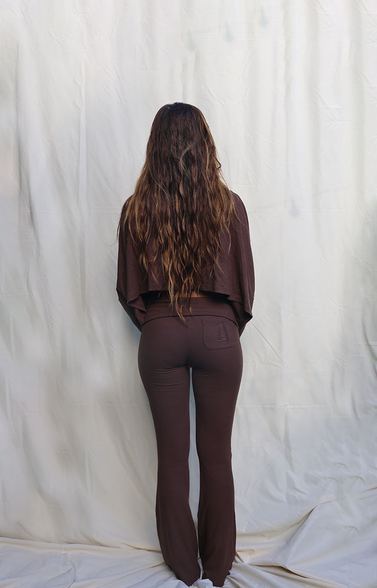 Person wearing a brown outfit standing against a white curtain tai swim co brown chocolate espresso long sleeve cotton lounge comfy outfits from oahu kailua hawaii