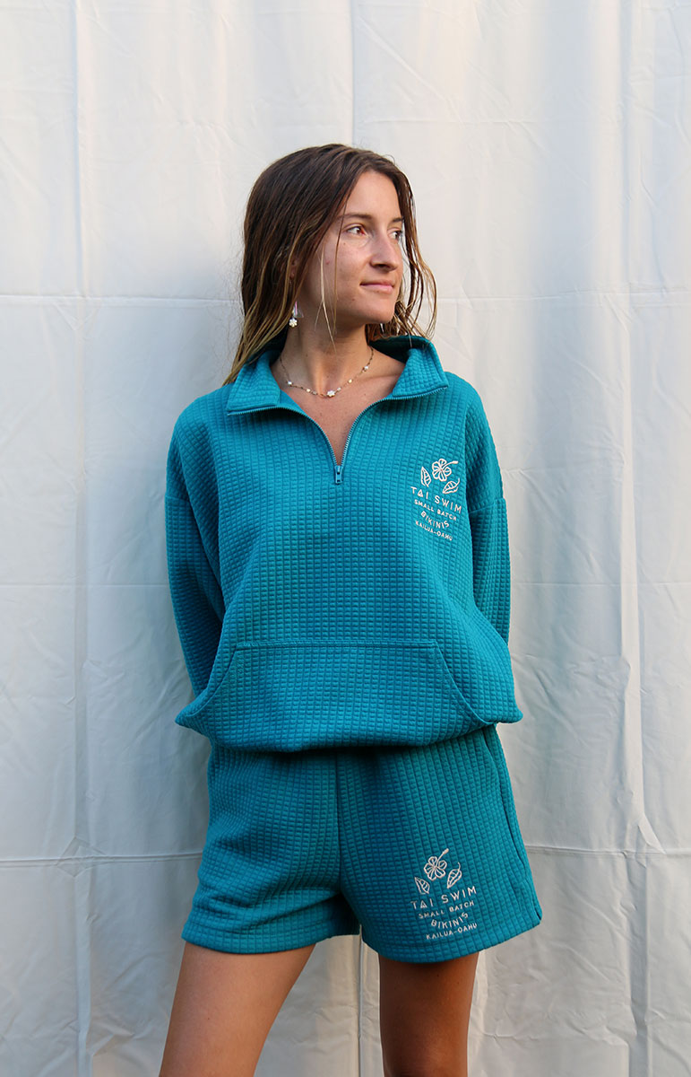 Elevate Your Summer Comfort with the Shannah Matching Shorts by Tai Swim Co. These cozy bottoms feature a textured design and elastic waistband for a perfect fit. Crafted from a recycled waffle cotton/poly blend, they combine sustainability with style. Available in classic swim colors with a custom Tai Swim logo, these shorts offer a relaxed yet chic look. The soothing blue shade and tan embroidery add a touch of elegance to your casual attire