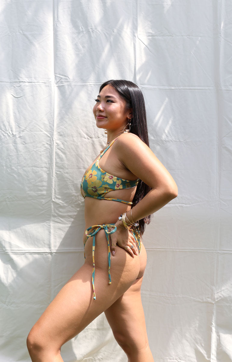 tai swim co tai top in milo green yellow hibiscus floral swimwear top and bottom from hawaii kailua oahu hawaiian swimwear tops and bottoms comfortable cheeky open scoop neck style tops and bottoms with milo hawaii flower sustainable size inclusive tops with adjustable strings with thong bottom