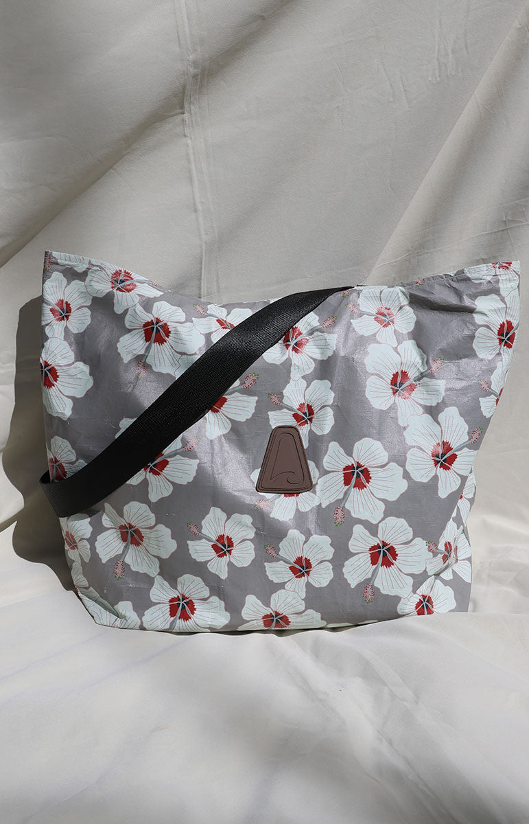 tai swim co kailua white hibiscus floral pattern bag made from tyvek with a black fabric strap