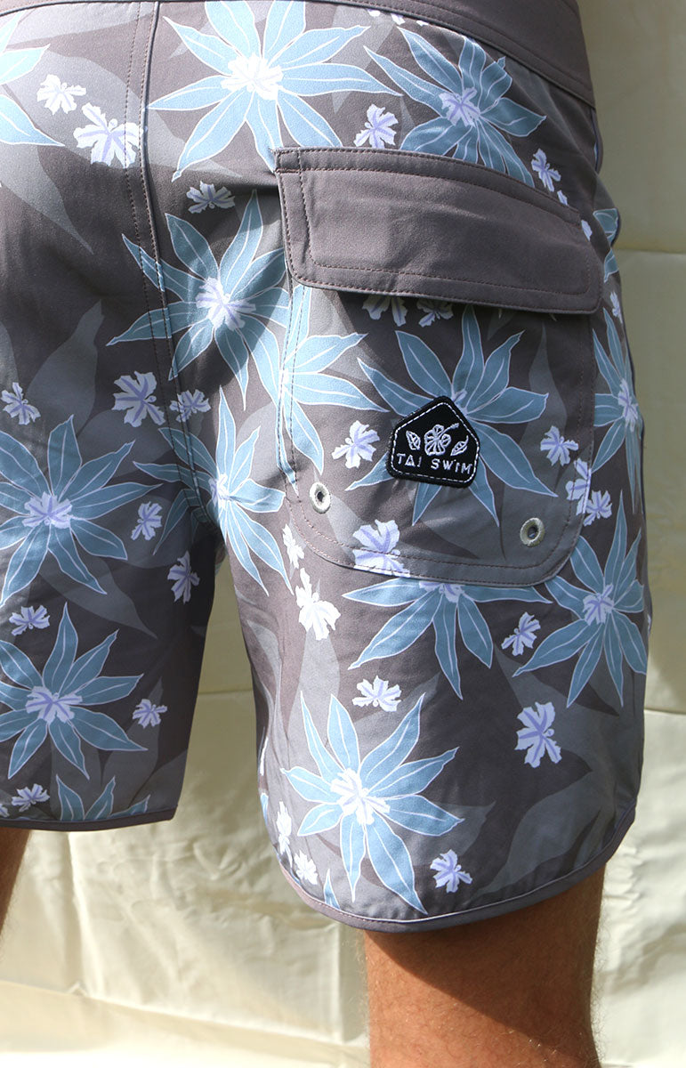 tai swim co austin boardshorts in matching kuahiwi and kahakai print designer 4 way recycled stretch boardshorts and trunks from hawaii kailua oahu sustainable swimwear brands from oahu matching bikini surf trunks made for surfing and kayaking in hawaii blue and purple naupaka flower 6 inch boardshorts for men with velcro pocket and good for surfing patch logo muted surfing boardshorts classic