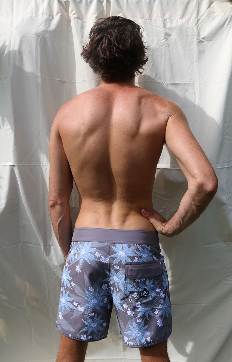 tai swim co austin boardshorts in matching kuahiwi and kahakai print designer 4 way recycled stretch boardshorts and trunks from hawaii kailua oahu sustainable swimwear brands from oahu matching bikini surf trunks made for surfing and kayaking in hawaii blue and purple naupaka flower 6 inch boardshorts for men with velcro pocket and good for surfing