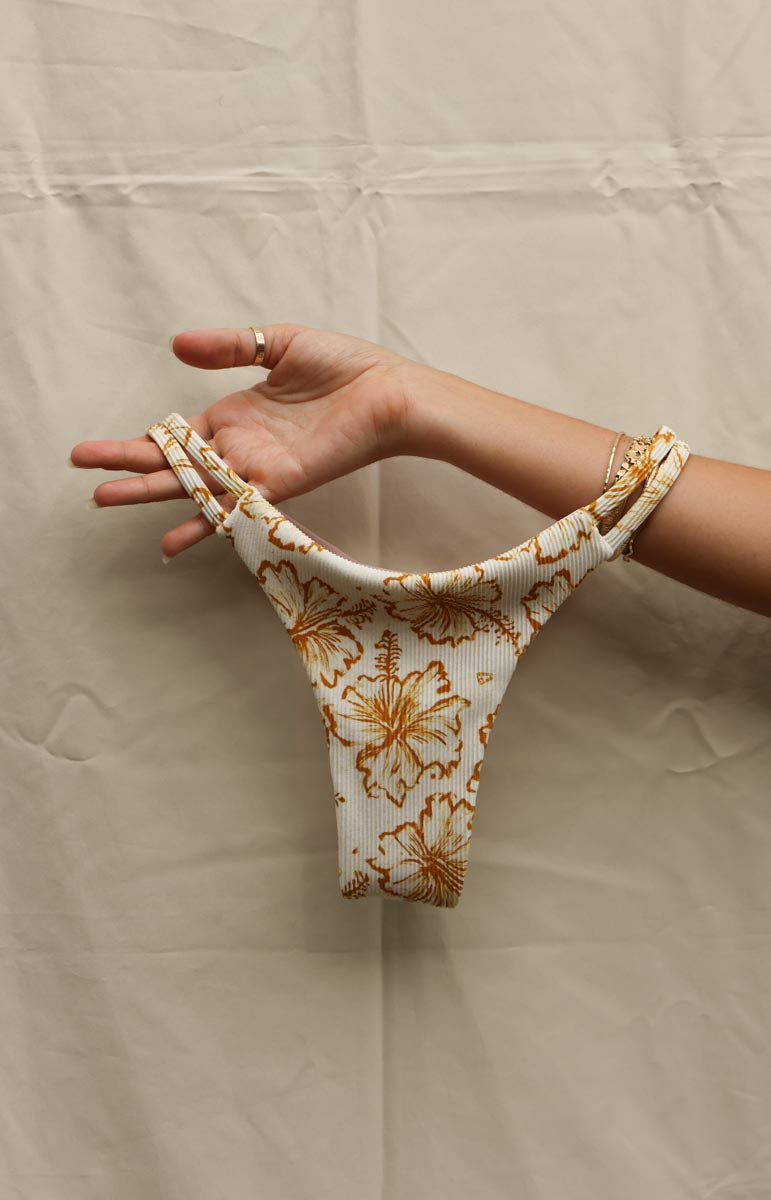 tai swim co devin yellow bikini bottom hibiscus waimea floral print arm holding bikini flatlay