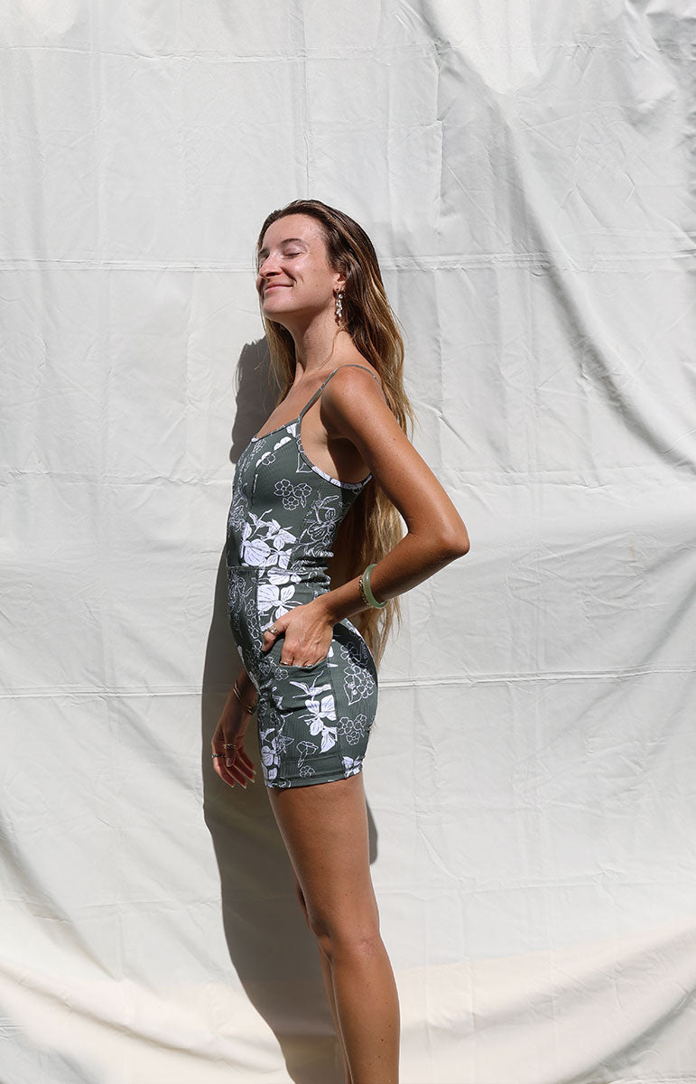 tai swim co kimi romper in pua green puakenikeni print with white ginger florals hand drawn on a green background activewear for yoga and pilates from oahu kailua hawaii