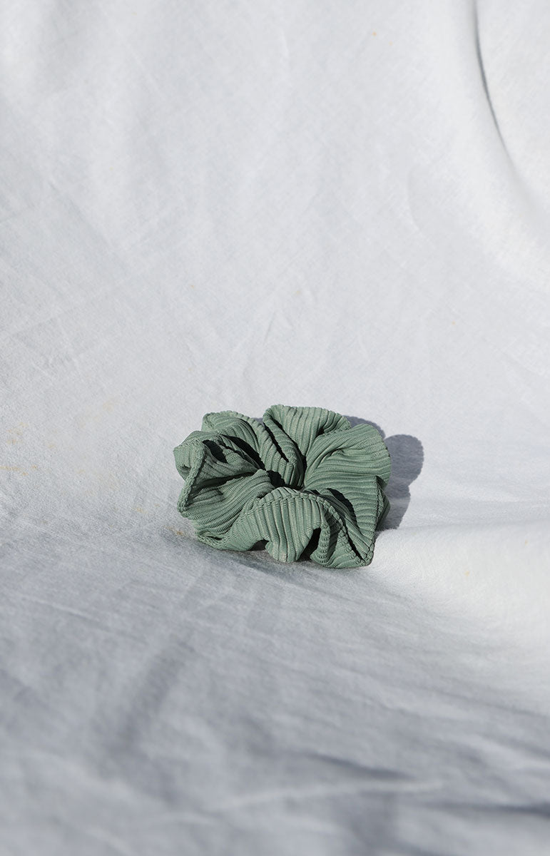 close up bright sustainable swimwear green foam smooth waterproof scrunchie ethically made eco friendly scrap material ponytail holder from hawaii fern ribbed textured hair accessory