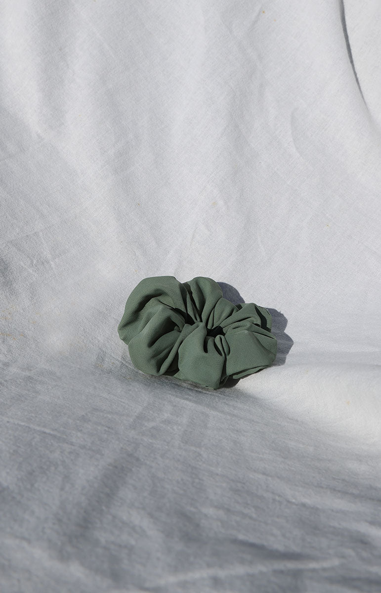 close up bright sustainable swimwear green foam smooth waterproof scrunchie ethically made eco friendly scrap material ponytail holder from hawaii mahina smooth earth tone scrunchie
