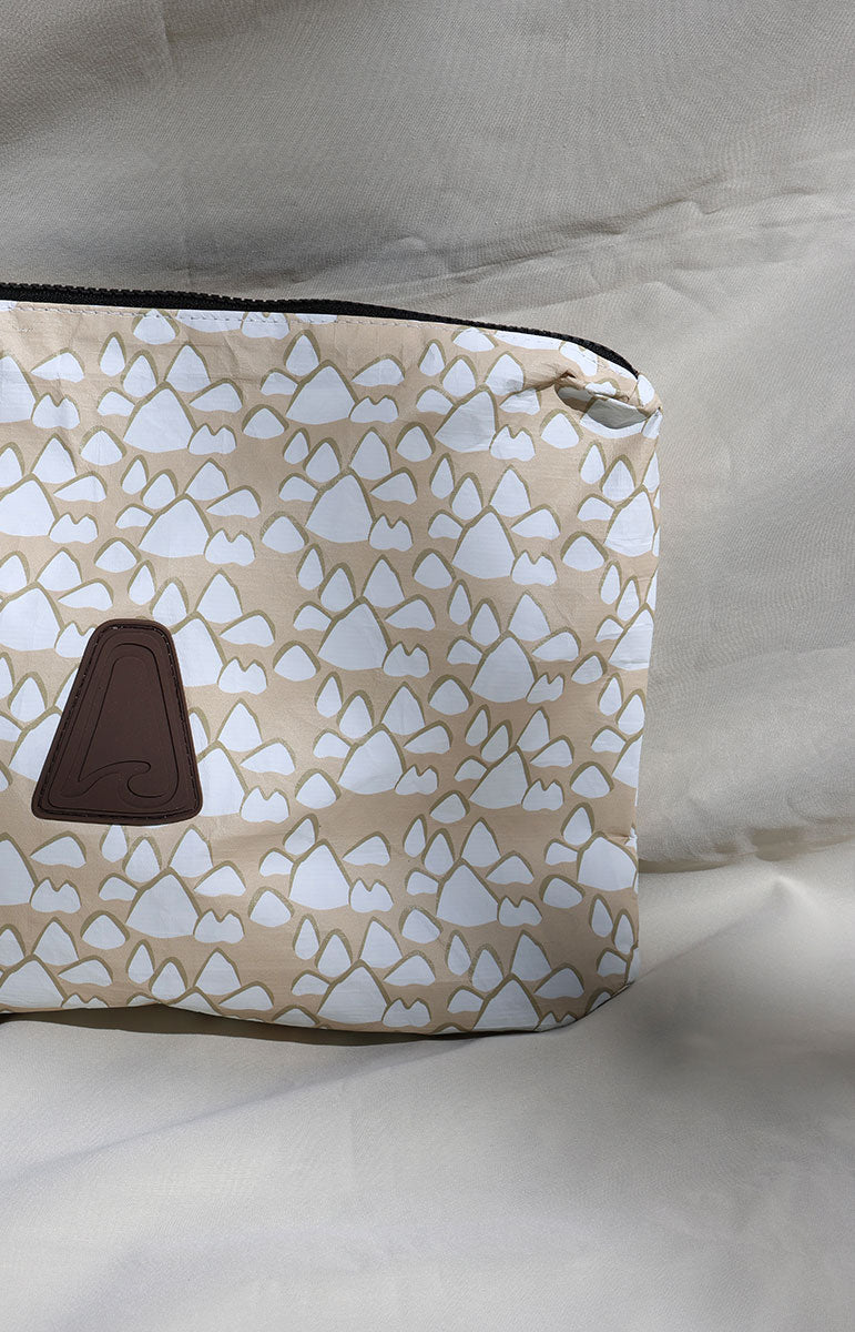Tai Swim co Cosmetic bag with geometric conus shell pattern on a light background