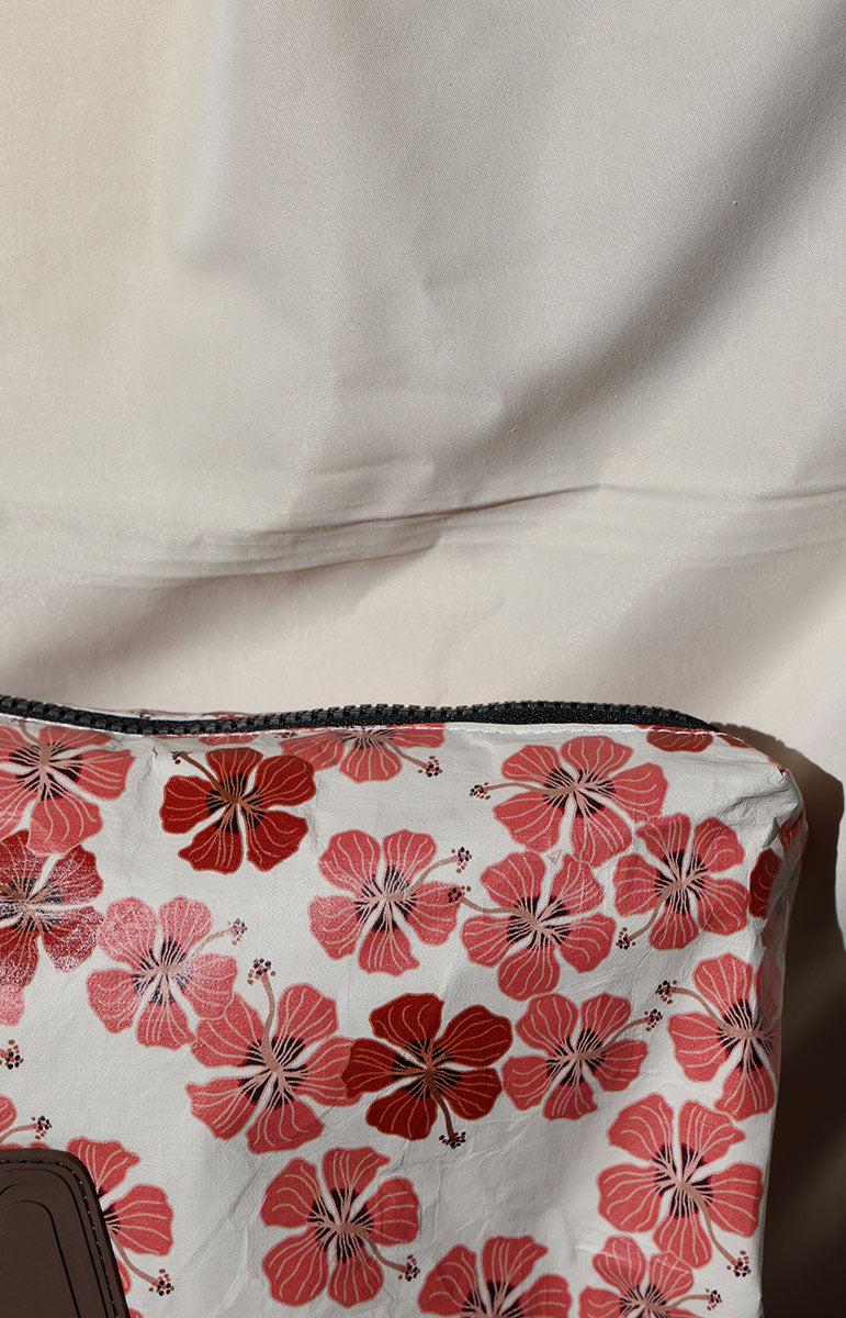 Floral-patterned fabric tyvek bag with red flowers on a white background, draped over a surface.