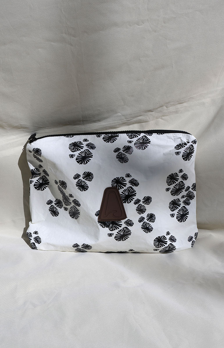 White opihi black pouch with black floral pattern and brown clasp on a white background
