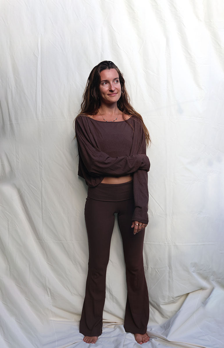 Woman wearing a brown outfit standing against a white backdrop tai swim co shaiann top long sleeve crop top in espresso