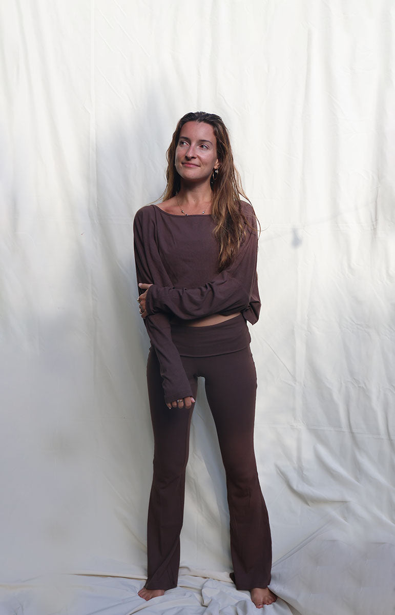 Person wearing a brown outfit standing against a white curtain tai swim co brown chocolate espresso long sleeve cotton lounge comfy outfits from oahu kailua hawaii