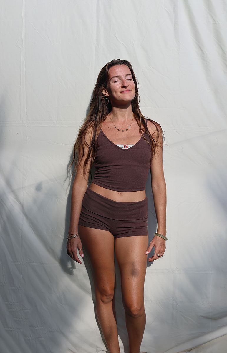 Woman wearing a brown tank top and shorts against a white background tai swim co shannah tank top in espresso brown adjustable top and foldover shorts from oahu kailua hawaii