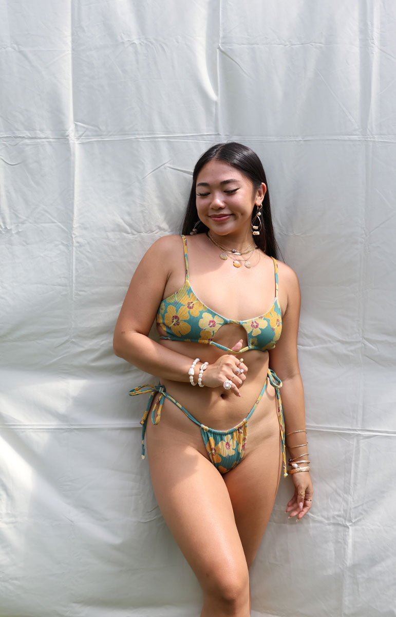 tai swim co tai top in milo green yellow hibiscus floral swimwear top and bottom from hawaii kailua oahu hawaiian swimwear tops and bottoms comfortable cheeky open scoop neck style tops and bottoms with milo hawaii flower sustainable size inclusive tops with adjustable strings