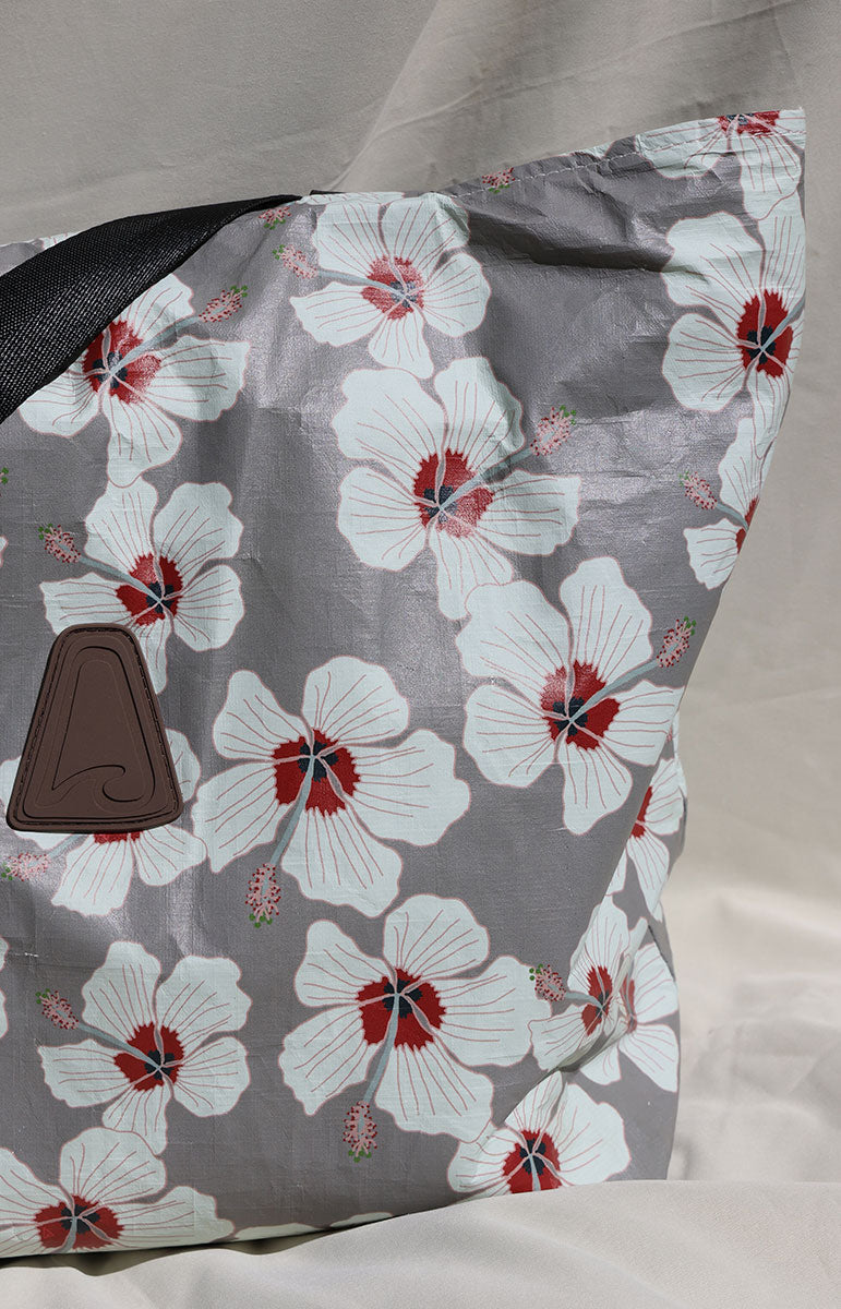 tai swim co kailua white hibiscus floral pattern bag made from tyvek with a black fabric strap with matching bikinis