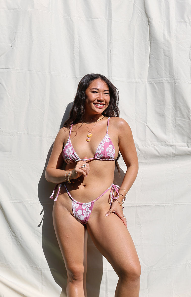 shannah wearing the joelle triangle bikini top in hana with the matching tai bottoms in hana they are stringy adjustable bikinis handmade in hawaii with super skimpy cheeky thong coverage and reversible seamless stitching perfect pink bublegum color in the sun