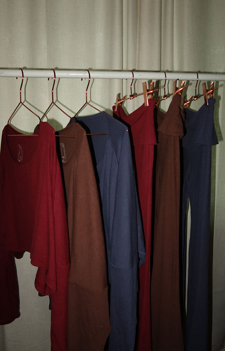 Collection of colorful shirts on hangers against a neutral background tai swim cotton lounge collection